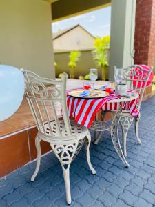 2 sillas y mesa con mantel rojo y blanco en KB Guesthouse en Groblersdal