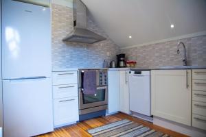 a kitchen with white appliances and brick walls at Ängagården - Gårdslyckan in Våxtorp