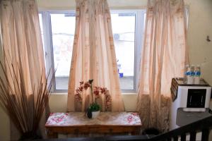a window with curtains and a table with flowers on it at Myra Hotel Mersing in Mersing