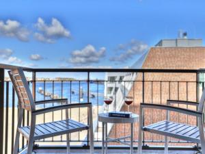 two chairs and two glasses of wine on a balcony at Ohlerich Speicher App_ 19 in Wismar