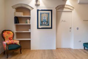 una habitación con una silla y un cuadro en la pared en Losanna Suites, en Campiglia Marittima
