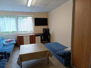 Cette chambre comprend deux lits, un bureau et une table. dans l'établissement Hostel WELINEK gratis parking, à Stęszew