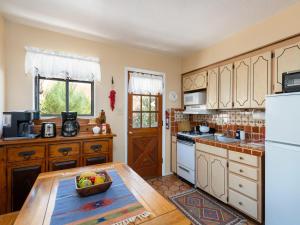 a kitchen with a table with a bowl of fruit on it at Rio Vista Casita in Santa Fe