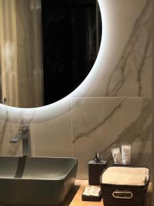 bagno con lavandino e specchio di Hotel Masaniello Luxury a Casoria