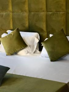 a white bed with three pillows on top of it at Hotel Masaniello Luxury in Casoria