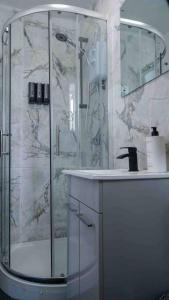 a bathroom with a glass shower and a sink at Stunning Two Bed City Centre Apartment in Hunslet