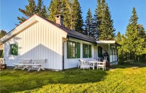 a white house with a table and chairs in the yard at Lovely Home In Hnefoss With House A Panoramic View in Hønefoss