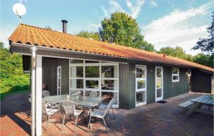 ein Haus mit einer Terrasse mit einem Tisch und Stühlen in der Unterkunft Amazing Home In Glesborg With Kitchen in Fjellerup Strand