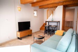 a living room with a blue couch and a tv at Charmant Bas de Villa au cœur de la Provence in Manosque