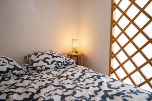 a bed with blue and white sheets and a lamp at Charmant Bas de Villa au cœur de la Provence in Manosque +8 photos