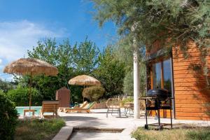 a patio with a grill and chairs and umbrellas at Charmant Bas de Villa au cœur de la Provence in Manosque