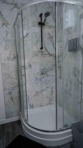 a shower with a glass door with a cross on the wall at Stunning Two Bed City Centre Apartment in Hunslet +35 photos