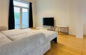 Il comprend un salon doté d'un canapé et d'une télévision à écran plat. dans l'établissement 1 Bedroom Nice Apartment In Oostende, à Ostende