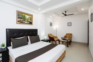 a bedroom with a bed and a desk and chairs at Collection O Hotel Residency Near Dwarka Sector 21 Metro Station in New Delhi