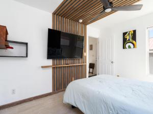 a bedroom with a bed and a flat screen tv at Return House in Santa Fe