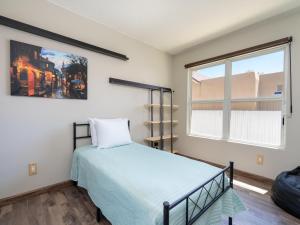 een slaapkamer met een bed en een raam bij Return House in Santa Fe