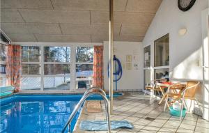 Fjellerup StrandにあるStunning Home In Glesborg With 4 Bedrooms, Sauna And Wifiのスイミングプール、テーブルと椅子が備わる家