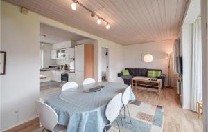 ヒュールスミンネにあるStunning Home In Juelsminde With 3 Bedrooms And Wifiのリビングルーム(テーブル、椅子、ソファ付)