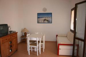 uma sala de estar com uma mesa, um sofá e uma televisão em Casa Vacanze Stella Marina em Monte Nai