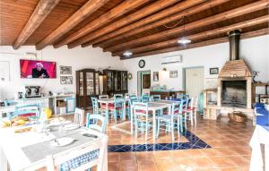 a dining room with tables and chairs and a fireplace at Cozy Home In Arenella With Outdoor Swimming Pool in Arenella