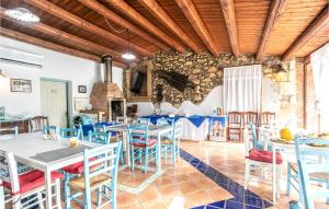 a dining room with tables and chairs and a stone wall at Cozy Home In Arenella With Outdoor Swimming Pool in Arenella