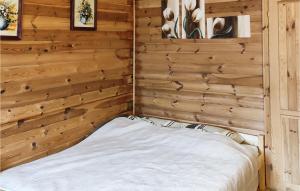 a bed in a room with wooden walls at Pet Friendly Home In Wiselka With House A Panoramic View in Wisełka