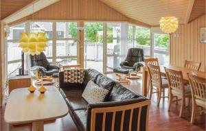 uma sala de estar com um sofá, uma mesa e cadeiras em Stunning Home In Glesborg With 4 Bedrooms, Sauna And Wifi em Fjellerup Strand