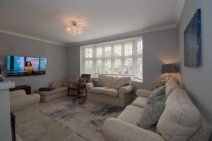 sala de estar con sofás y TV en Elegant and spacious private room with ensuite, en Luton