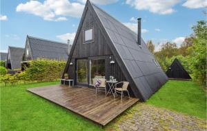 a black triangular house with a wooden deck at Gorgeous Home In Fars With Kitchen in Farsø