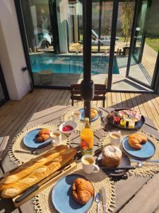 a table with breakfast foods and drinks on it at Au p'tit bonheur in Rothbach