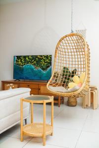 a living room with a rattan chair and a couch at The Horizon Ipoh By Iconique Espace in Ipoh