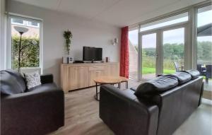 een woonkamer met 2 leren banken en een televisie bij Lovely Home In Vlagtwedde With Kitchen in Vlagtwedde