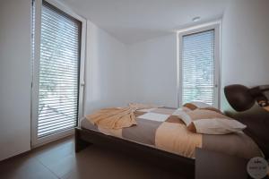 a bedroom with a bed and two large windows at WakeUp Lux-City 