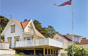 a house with a balcony and an american flag at Amazing Home In Skjrhalden With Kitchen in Skjærhollen