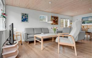 FjellerupにあるAwesome Home In Glesborg With 3 Bedrooms And Wifiのリビングルーム(ソファ、テーブル付)