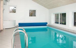 - une piscine dans une maison dotée d'une baignoire et de fenêtres dans l'établissement Cozy Home In Glesborg With Indoor Swimming Pool, à Fjellerup Strand