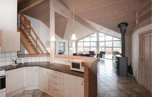 une cuisine avec des placards blancs et un comptoir dans l'établissement Cozy Home In Glesborg With Indoor Swimming Pool, à Fjellerup Strand