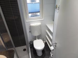 a small bathroom with a toilet and a window at Vakantiepark Camping de Peelpoort in Heusden