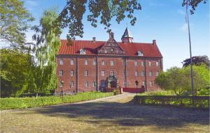 un grand bâtiment en briques rouges avec un toit rouge dans l'établissement Pet Friendly Home In Grenaa With Wifi, à Brøndstrup