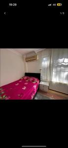 a small bedroom with a bed with a pink blanket at 1+1 Flat in Fatih Aksaray in Istanbul