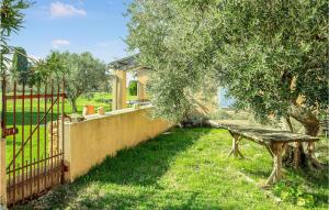 a fence with a wooden bench next to a tree at Beautiful Home In Valréas in Valréas +16 photos