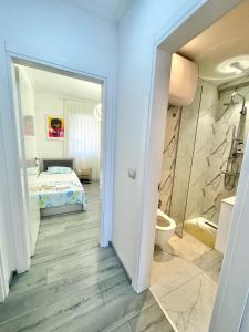 a bathroom with a toilet and a bed in a room at Durres Currila RELAX Beach Lifestyle in Durrës