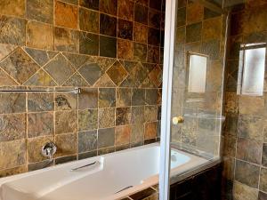 ein Badezimmer mit einer Badewanne und einem Waschbecken in der Unterkunft Covesto Guesthouse - Waterkloof in Pretoria