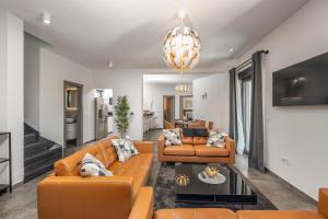 ein Wohnzimmer mit orangefarbenen Möbeln und einem Kronleuchter in der Unterkunft Rustic Luxury Villas Dalma & Dalmata in Murvica