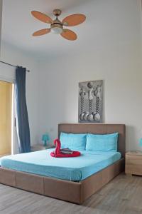 a bedroom with a bed with a ceiling fan at BoaOp Apartaments in Sal Rei