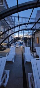 a group of white lounge chairs in a building at Dobre smaki at Wczasowa8 sea resort in Sarbinowo