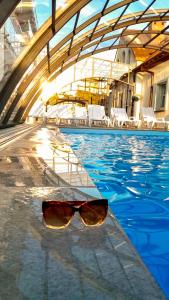 un par de gafas de sol sentadas en el borde de una piscina en Dobre smaki at Wczasowa8 sea resort, en Sarbinowo