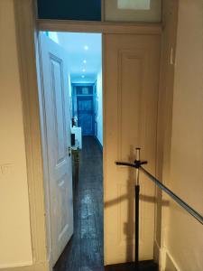 a hallway with an open door with a sword at Hostel Sun River in Almada