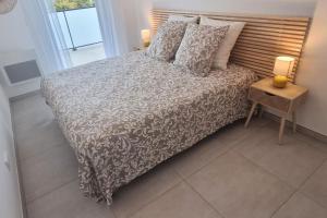 a bedroom with a bed and a table with a night stand at LE SEGRETO, Appt Neuf dans résidence de Standing, Superbe Déco, Centre, 2 Parkings Privés, Climatisation in Sète