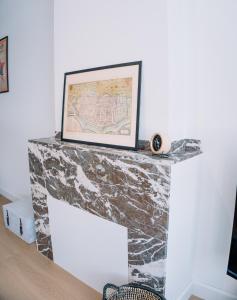 a stone fireplace with a picture on top of it at Appartement vlakbij Antwerpen centrum! in Antwerp